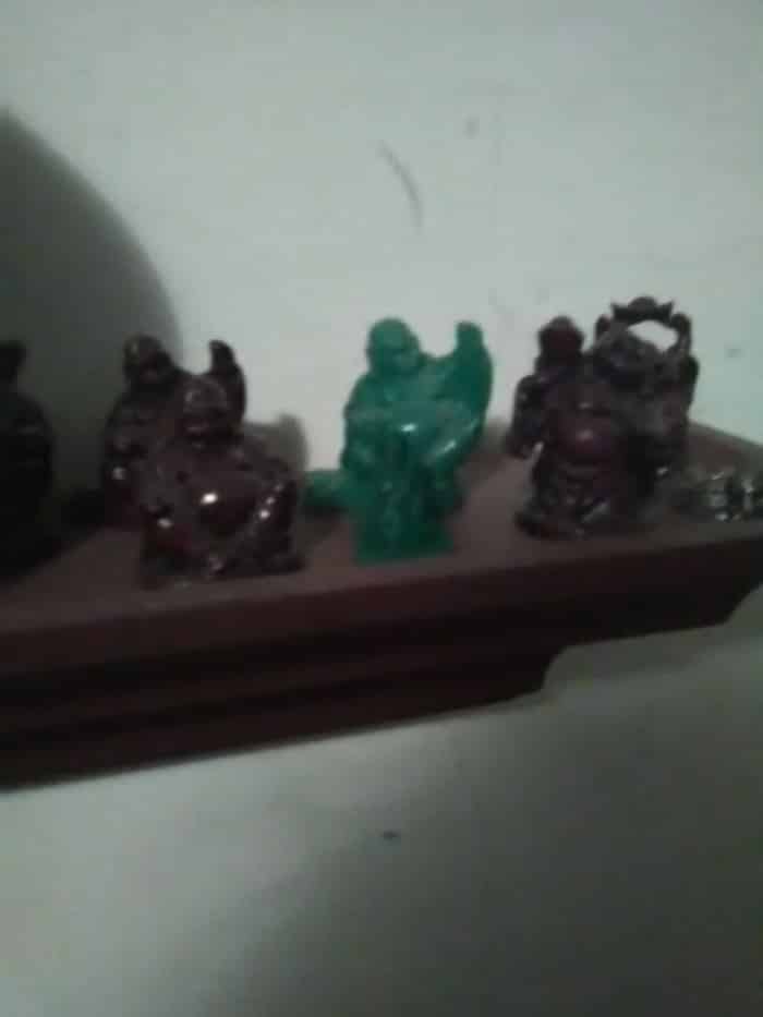 Le modèle imprimé en 3D est la petite statue en plastique vert devant le Bouddha rieur de jade (vert).  Dans Cura, les objets 3D peuvent être mis à l'échelle pour différentes tailles et formes légèrement différentes.